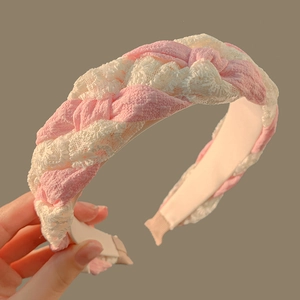 Detailed view of pink and white lace braided headband with soft fabric lining texture