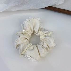 Dettaglio dell'elastico in pizzo con trama satinata e fiocco con perla decorativa