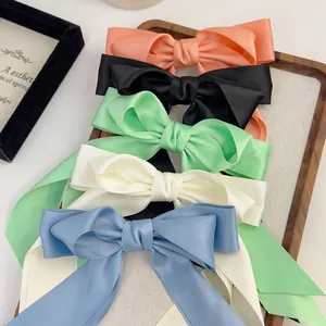 Set of 5 premium satin bow hair clips in pastel colors on a wooden decorative tray