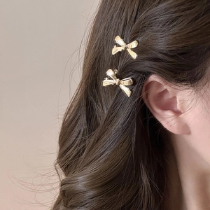 Elegantes Set aus zwei goldenen Schleifen-Haarspangen aus Metall mit Bürstentextur