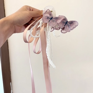 Detail der rosa bestickten Schmetterlings-Haarklammer mit Perlen und langen Bändern