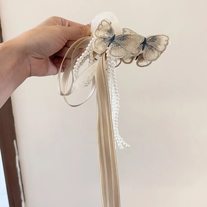 Detail-Ansicht der eleganten Haarklammer mit Stickerei, Perlen und champagnerfarbenen Bändern
