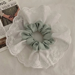 Chouchou en dentelle avec bande de soie verte pour une coiffure élégante