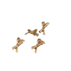 Set mit vier goldenen Metall-Haarclips in Schleifenform mit polierter Oberfläche