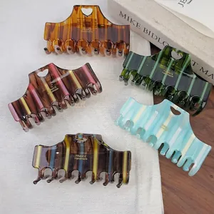 5-piece set of large striped acetate shark hair claws with heart cutout and gold logo