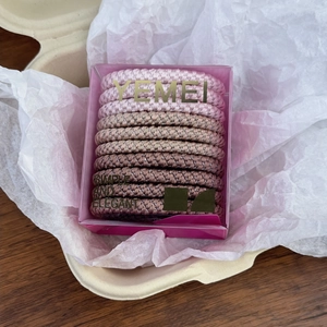 Macro shot of durable thick woven hair ties in pink gradient colors set in a gift box
