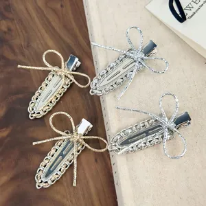 Barrette à cheveux élégante avec nœud en métal doré et argenté et détails de chaîne