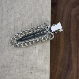 Pince à cheveux nœud en métal argenté avec motif chaîne creuse sur bois