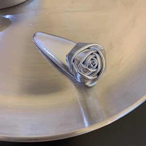 Minimalistische silberne Rosen-Haarklammer mit Metallic-Ledertextur auf Metalltablett