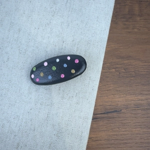 Vue détaillée de pois colorés sur la surface lisse en cuir de la pince à cheveux