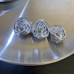 Detailansicht der silbernen Rosen-Haarklammer mit drei Blumen auf einem Metalltablett