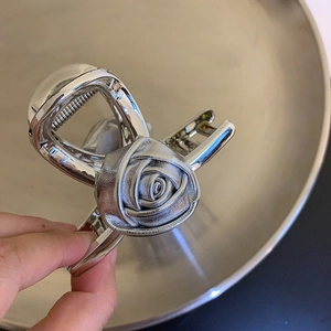 Detaillierte Nahaufnahme einer silbernen Rosen-Haarklammer mit strukturierten Metall-Blütenblättern