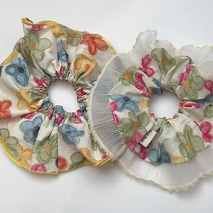 Floral scrunchies with colorful flower patterns, lace edges, and handmade label accents