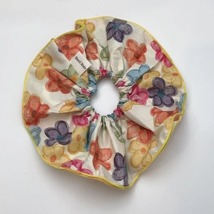 Detail of floral scrunchie with handmade label and yellow embroidered edge craft
