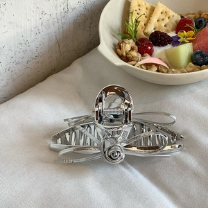 Elegant silver metal rose flower hair claw clip with pearls in a lifestyle setting