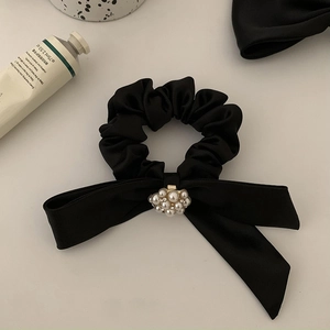 Elegant black satin scrunchie with faux pearl center embellishment for bun hairstyles