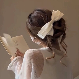 Elegant white satin oversized bow hair clip styled in a French updo hairstyle