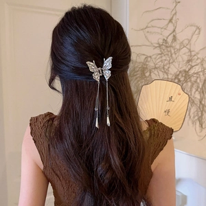 Silver butterfly hair claw clip with tassels and rhinestones in an elegant updo