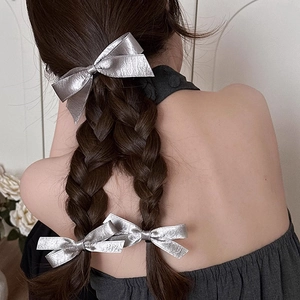 Elegant silver bow hair clip set for women showing three metallic bows on a half-up hairstyle