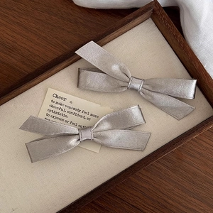 Elegant pair of silver-grey satin bow hair clips in a classic minimalist butterfly design