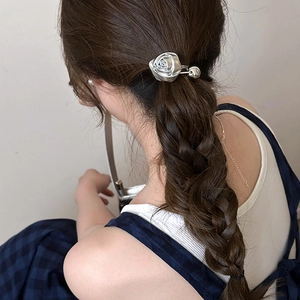 Elegant 3D silver rose metal hair clip accessory worn on a dark brown braided ponytail