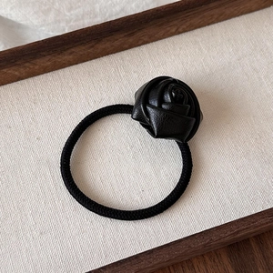 Elegant black faux leather rose hair tie with high elastic band on white fabric background