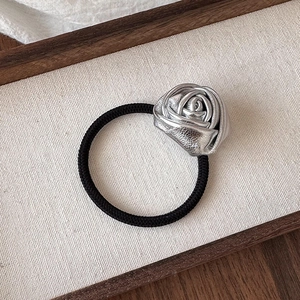 Close-up of metallic silver rose decoration on durable black elastic hair tie for women