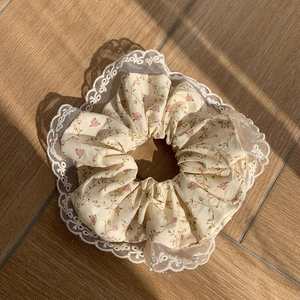 Chouchou floral avec bordure en dentelle et motif de fleurs sur fond de bois