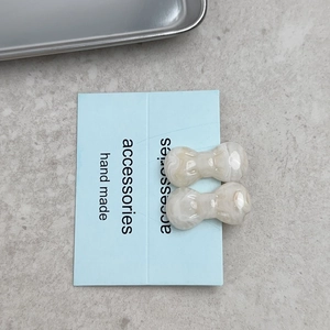Elegant cream marble bow-shaped hair clips for women displayed on a blue card