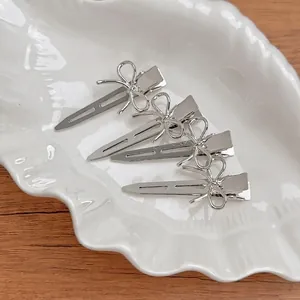 Lot de quatre barrettes à cheveux argentées avec design minimaliste de papillon