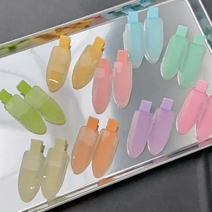 Lot de barrettes en résine aux couleurs macarons disposées sur un plateau en métal