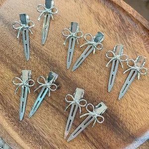 Lot de dix pinces à cheveux noeud en métal argenté poli sur un plateau en bois chic