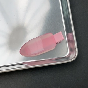 Détail d'une pince à cheveux en résine rose translucide avec base métallique chic
