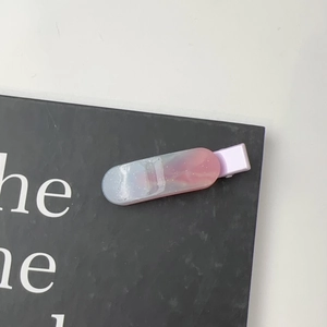 Close-up of a dreamy pink and blue gradient marble resin hair clip with silver glitter