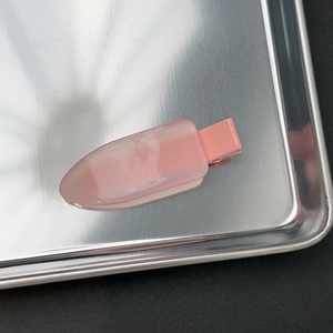 Gros plan sur la barrette à cheveux rose translucide mate en résine de qualité