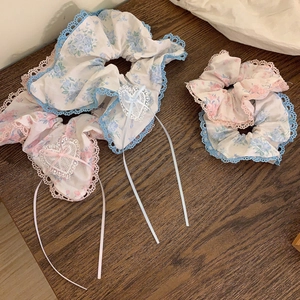 Détail de chouchous floraux avec bords en dentelle et appliques en forme de cœur blanc