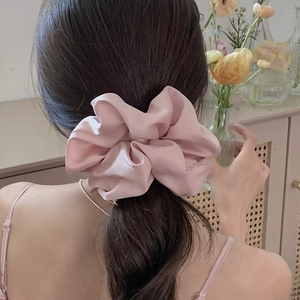 Elegant oversized soft pink satin scrunchie shown on a ponytail with a silky finish