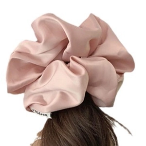 Elegant oversized pink satin silk hair scrunchie with soft glossy finish and brand label