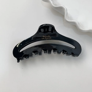 Pince à cheveux élégante en acétate noir avec inscription dorée et design ergonomique