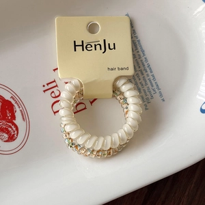 Détail de deux chouchous spirales comprenant des styles dégradé crème et imprimé fleuri