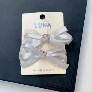 Détail de barrettes nœuds gris argenté avec dentelle et strass en cœur rose tendre