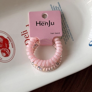 Détail d'élastiques spirales roses et floraux sur une assiette en céramique pour cheveux
