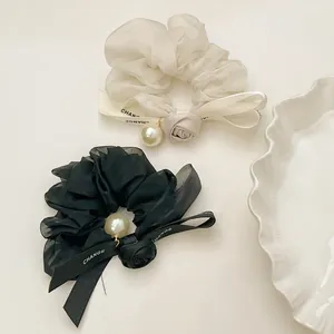 Detail of French vintage scrunchies with organza fabric, roses, pearls and ribbons