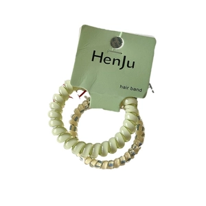 Lot de deux élastiques spirales vert pastel et rayés présentés sur carte support