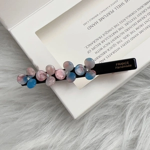 Detail view of handmade floral hair clip with gradient resin flowers and micro rhinestones