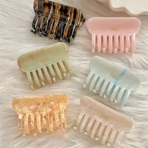 Ensemble élégant de six pinces à cheveux en acétate sur un fond en peluche blanc doux