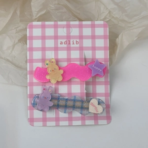 Détail de lot de 2 barrettes mignonnes en résine avec lapin et étoile sur carte rose