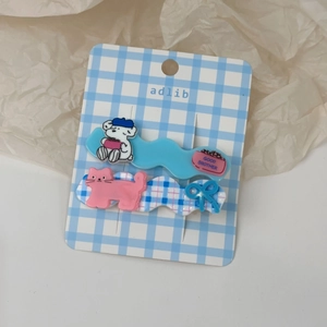Vue détaillée des barrettes en acrylique en forme de vague avec motifs d'ours et de chat
