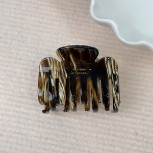 Detail of tortoiseshell acetate hair claw with golden Barrette La France lettering