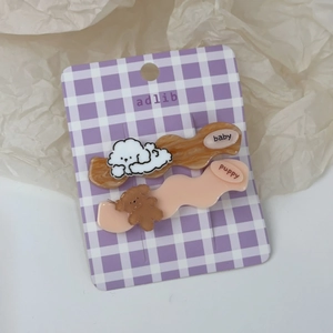 Détail de barrettes mignonnes chien et ours sur une carte à carreaux violets